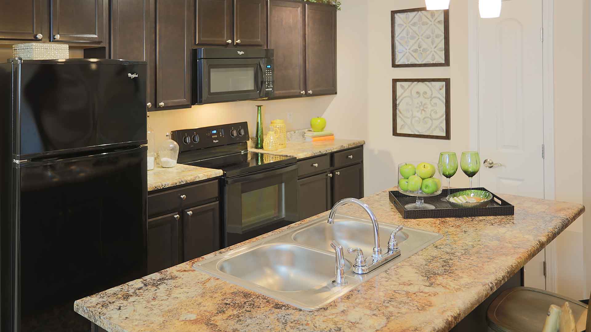 Apartment kitchen with an island and updated appliances at Brinley Place.
