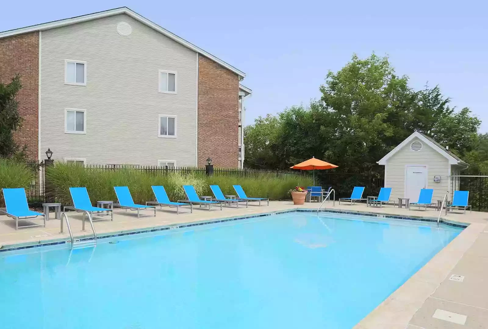 Community swimming pool surrounded by lounge chairs.