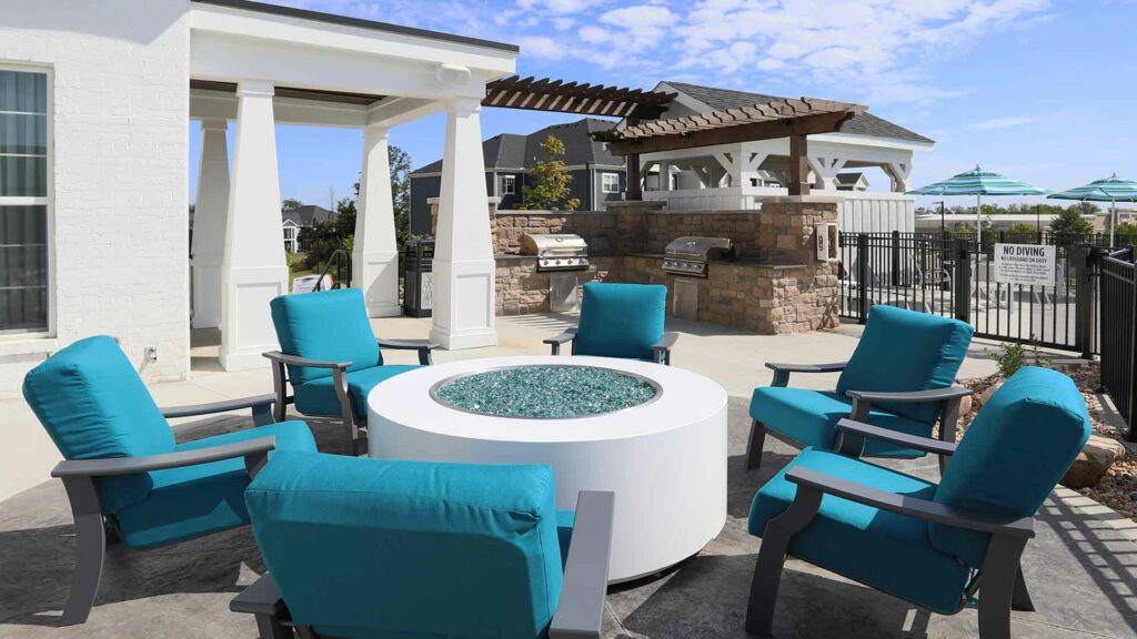 Furnished outdoor fire pit and grill area at Greyson on 27.