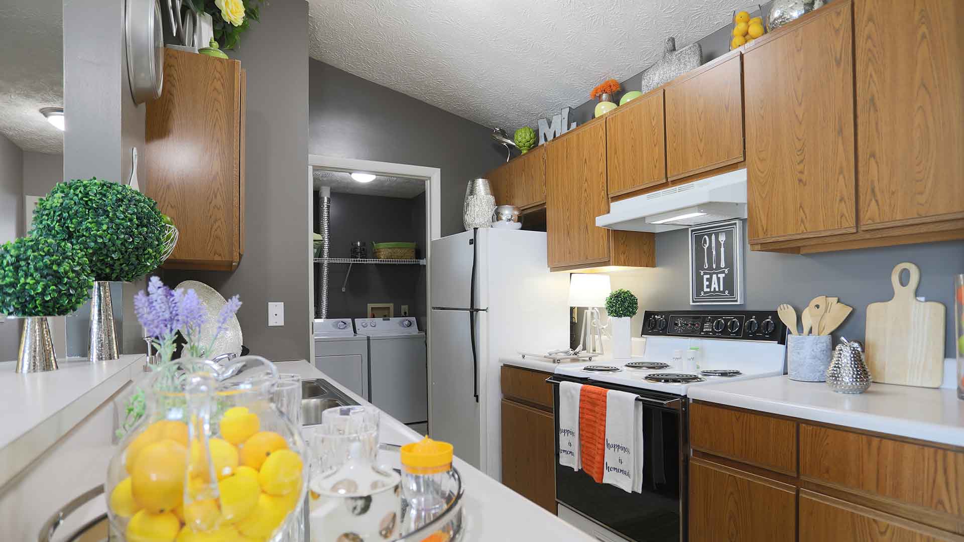 Kitchen with wooden cabinets and laundry room connection.