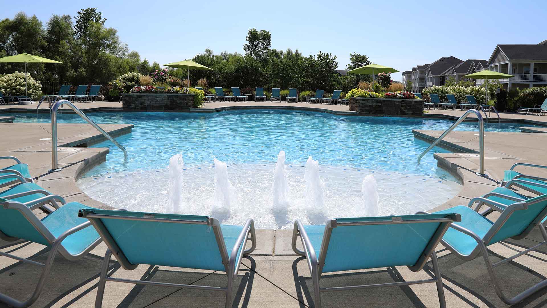 Lounge chairs lining the resort-style pool at Palmera.