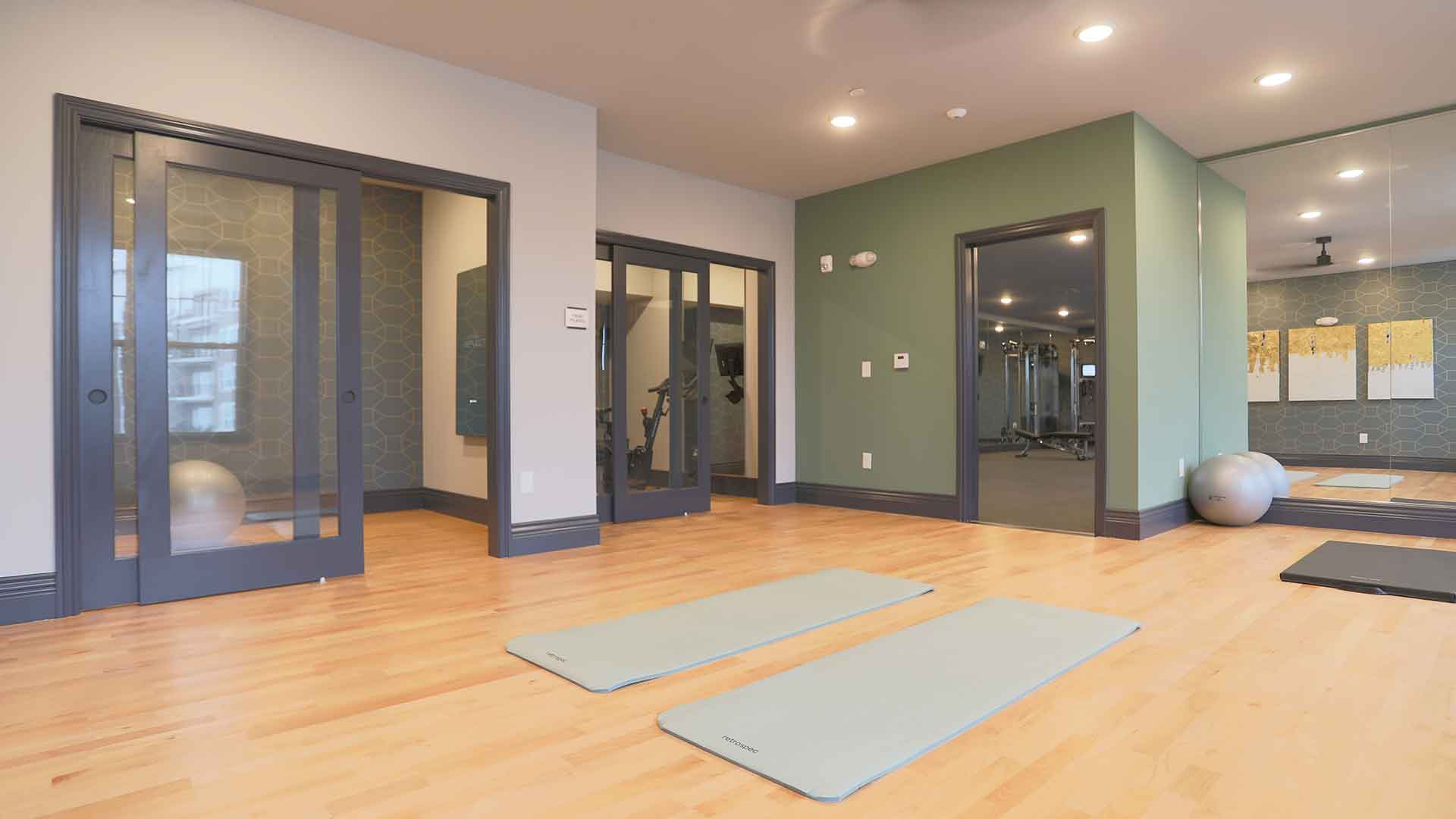 Spacious fitness area with open floor space and private rooms with sliding doors at Rialto on Hurstbourne.