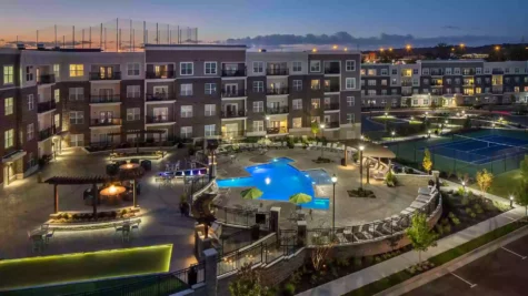 Aerial view of the resident retreat which includes a patio, swimming pool, and tennis court.
