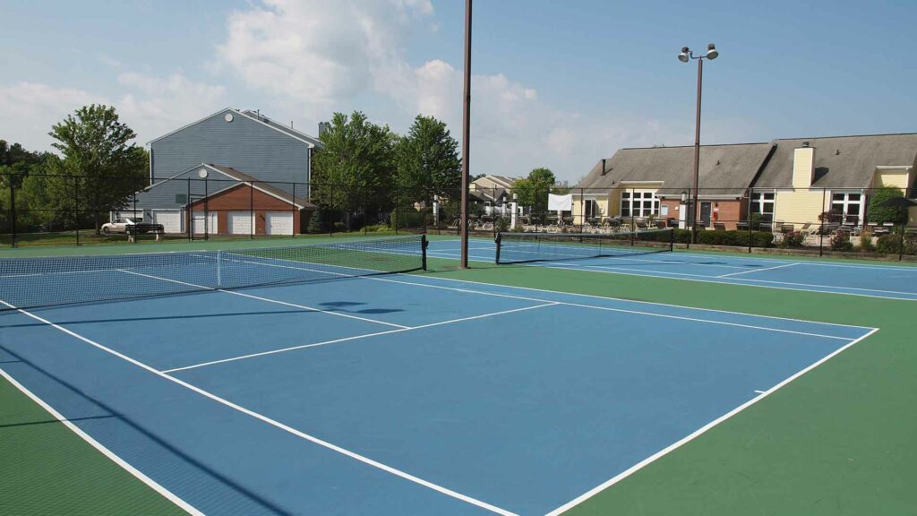 Two tennis courts next to clubhouse.