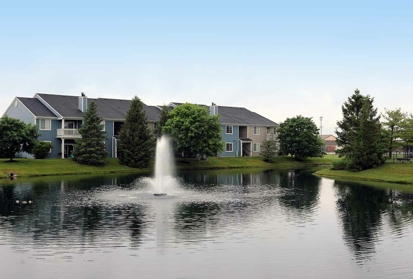 Wellington Place apartments near landscaping and a water feature.