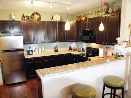 Spacious kitchen with java-stained solid wood cabinets and slab granite prep-island.