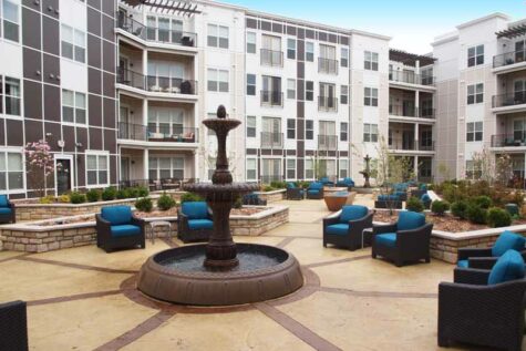 Community courtyard with lounge chairs, fountains, and fire features.