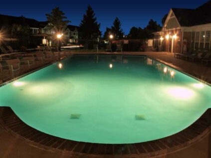 Community swimming pool lit up at night.