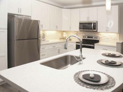 Elegant white kitchen with updated appliances and kitchen island.
