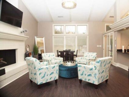 Decorated clubhouse common area with a TV and fireplace.