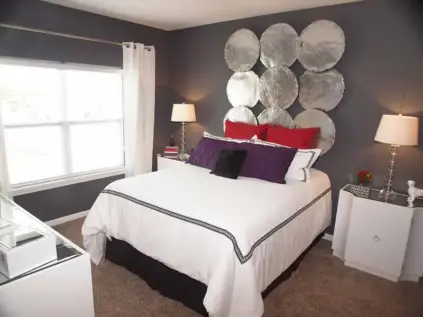 Apartment bedroom with large window and bedroom furniture.