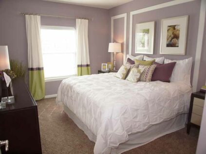 Carpeted bedroom with bedroom furniture and large window.