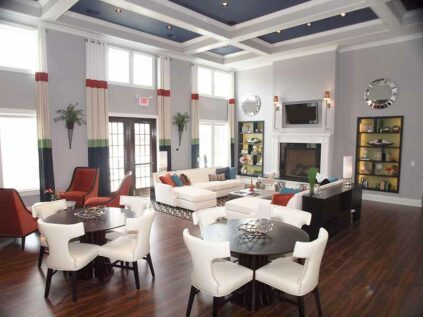 Beautiful clubhouse with lounge chairs, tables, and fireplace.