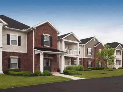 Landscaped exterior of Palmera with apartment entrance and patios.