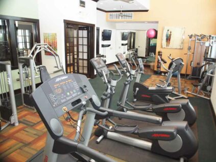 Fitness center with free weights, workout machines, and mirrors.