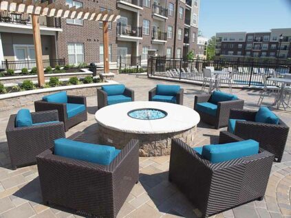 Community patio with fire pit and lounge chairs.