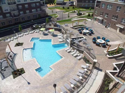 Aerial view of the resident retreat which includes a patio, swimming pool, and tennis court.