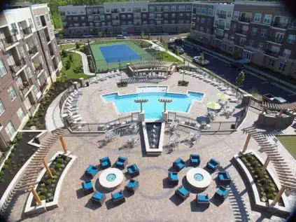 Aerial view of the resident retreat which includes a patio, swimming pool, and tennis court.