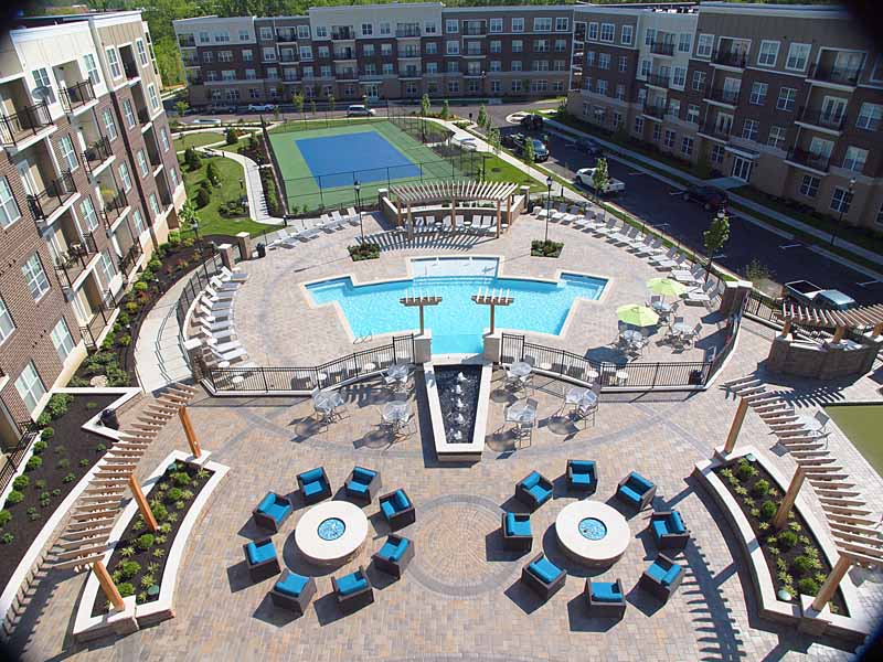 Aerial view of the resident retreat which includes a patio, swimming pool, and tennis court.