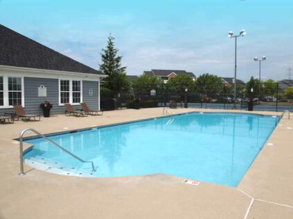 Apartment pool next to clubhouse and tennis court.