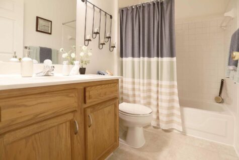 Bathroom with a single sink, bathtub shower, and toilet.