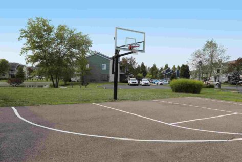 Outdoor basketball court next to apartment buildings.