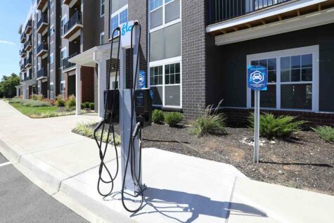 An EV charging station in front of a large apartment building.