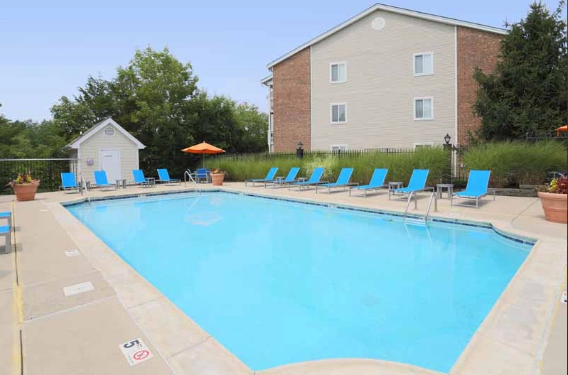 The outdoor pool deck at Fox Chase South, featuring lounge seating at the pool's perimeter.
