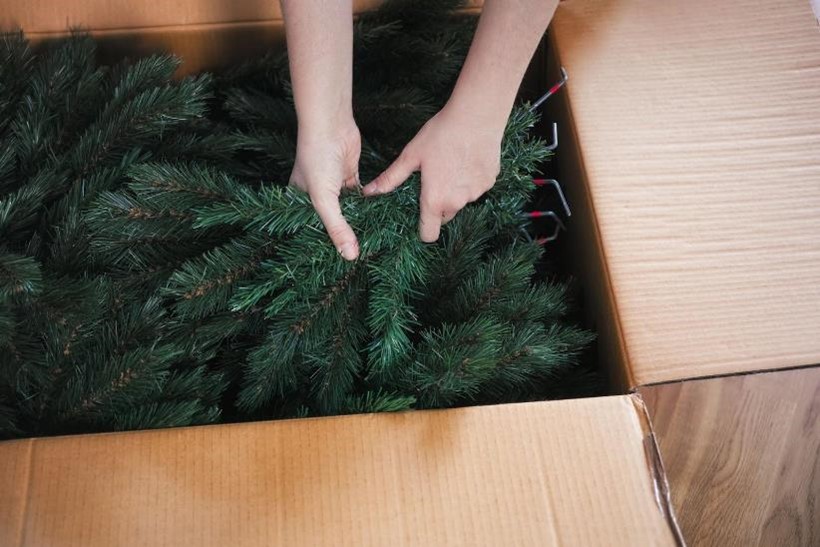 A person putting a Christmas tree away