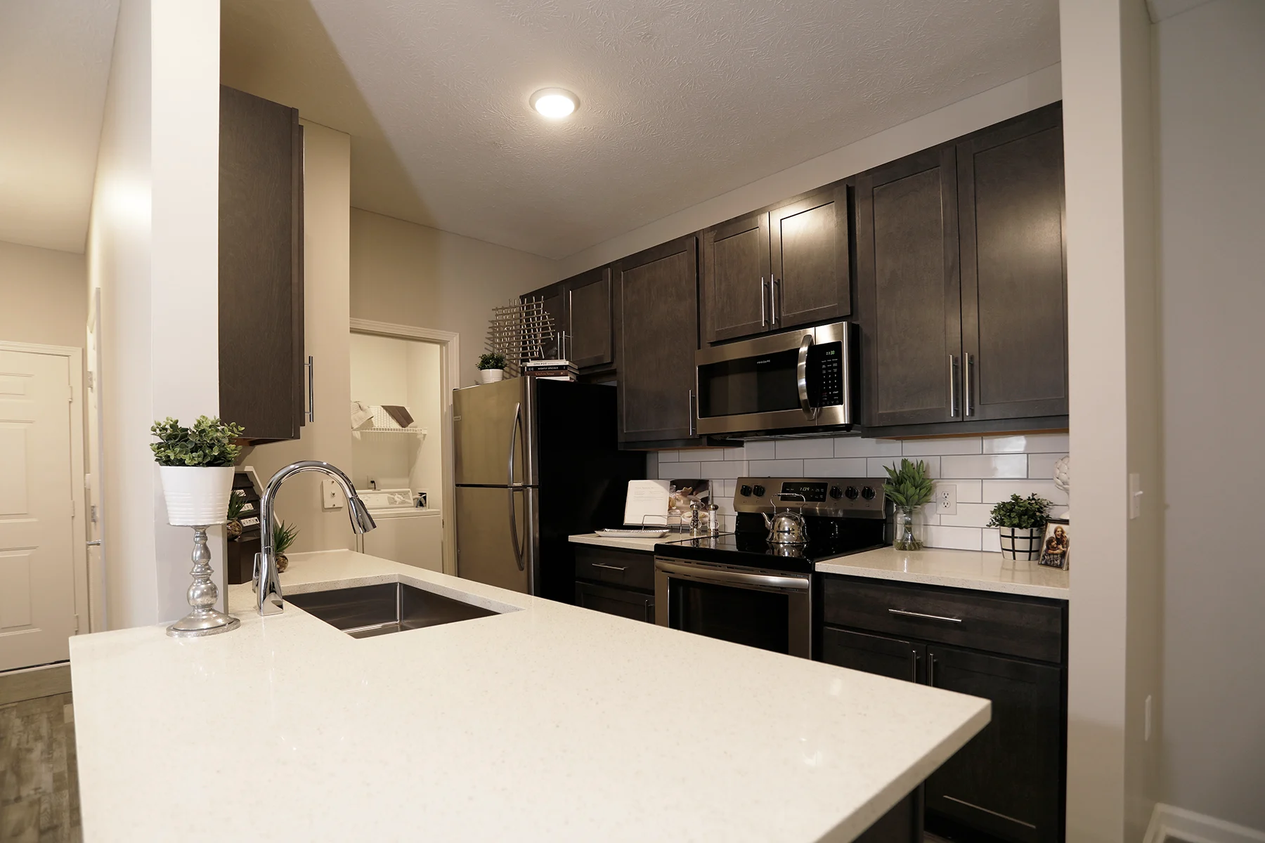 A kitchen featuring a stainless steel oven and dark cabinets with matching stainless steel hardware.