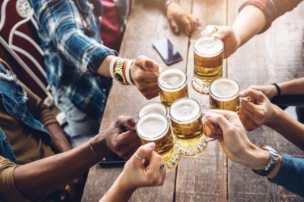 A group of friends cheersing with beers. 