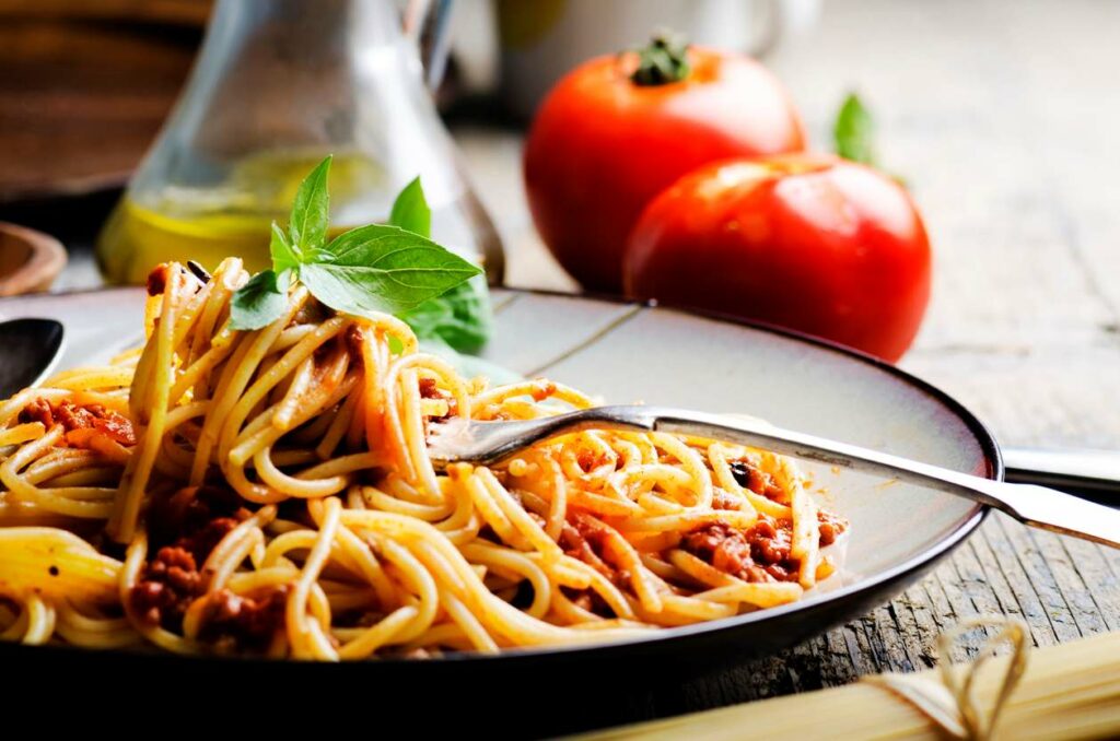 Spaghetti with meat sauce on a gray plate.