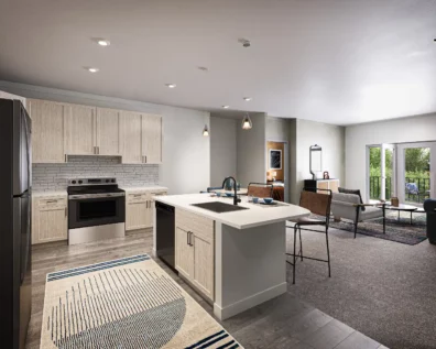Rendering of an open, luxury kitchen with modern appliances that is attached to the living room at Graphite Oakley.