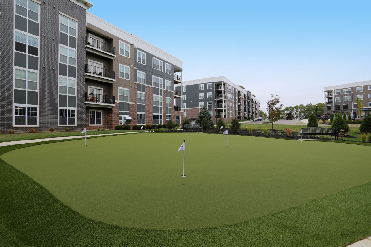 A view of the Allure community's golf course, facing apartment home facades and the street.