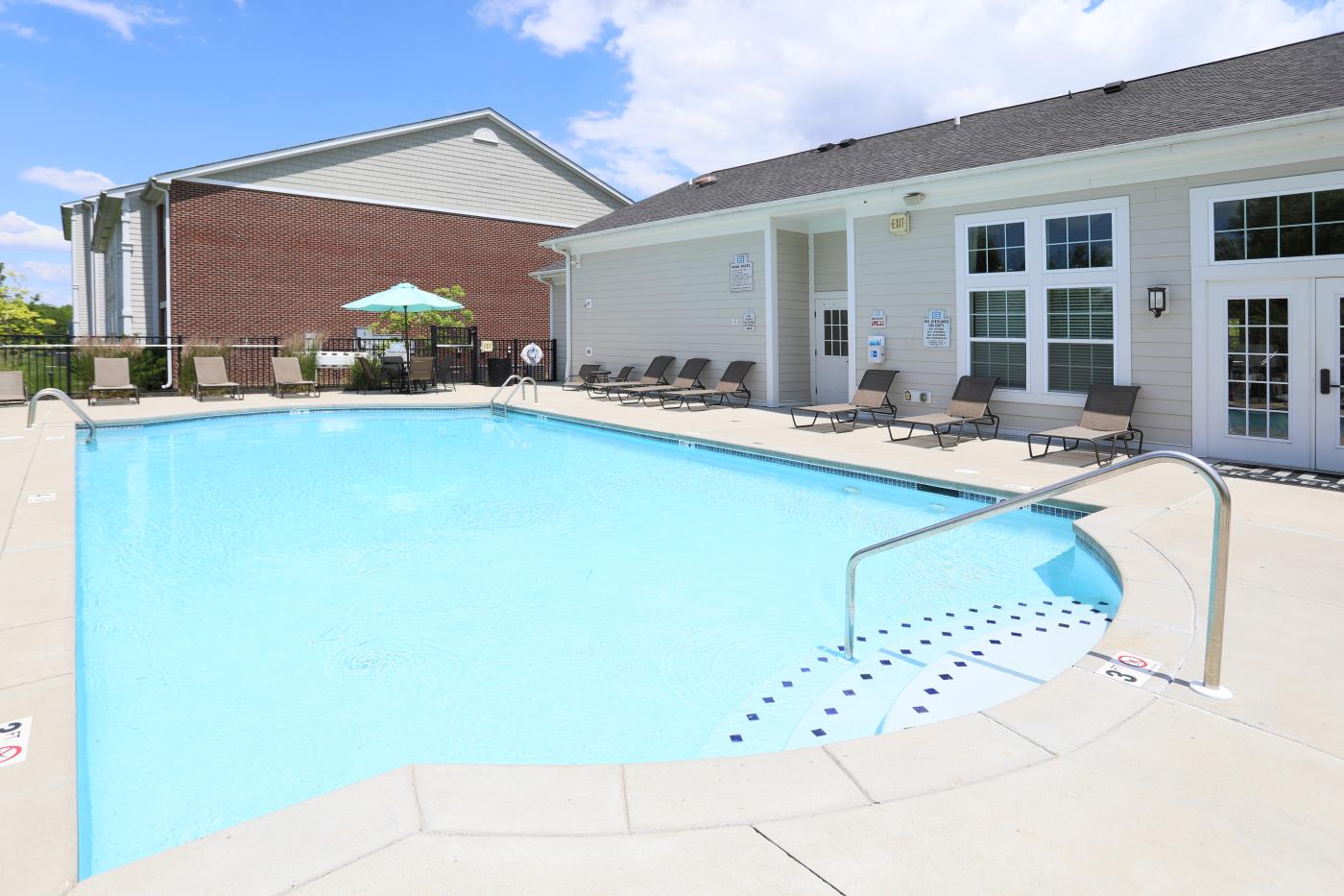 The outdoor pool and pool deck with seating at Brinley Place.