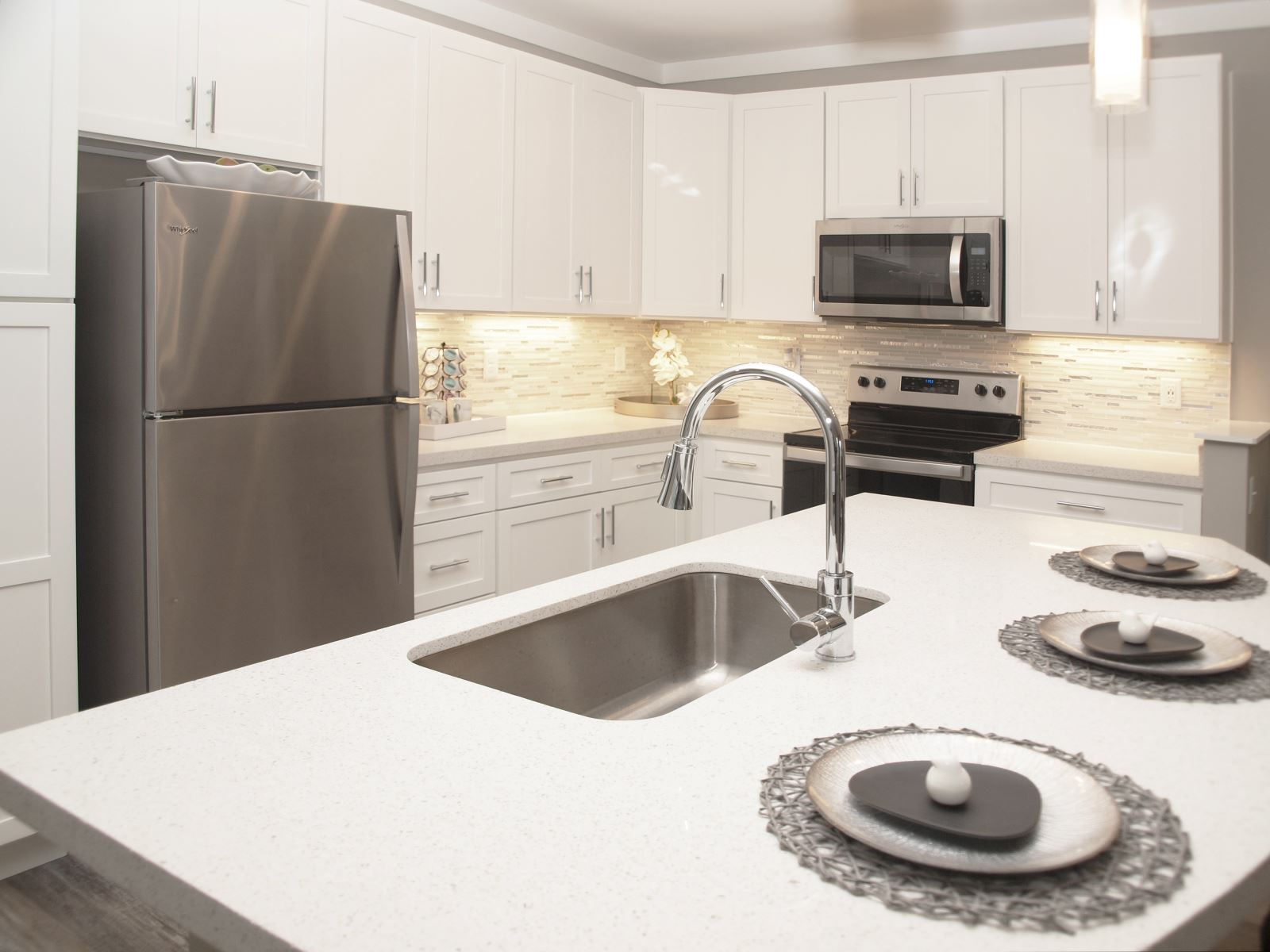 A view of an Element Oakwood apartment home's kitchen layout, cabinetry, and modern amenities.
