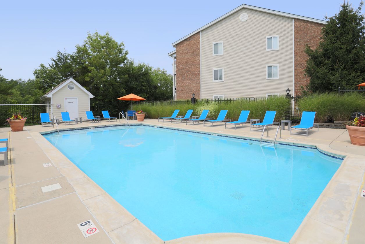 The outdoor pool deck at Fox Chase South, featuring lounge seating at the pool's perimeter.