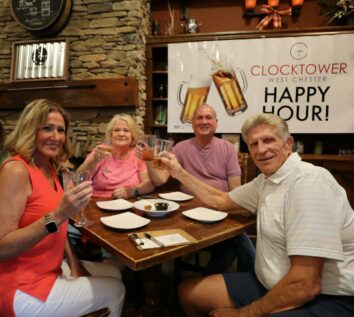Clocktower of West Chester residents at a dining table during a community happy hour event.