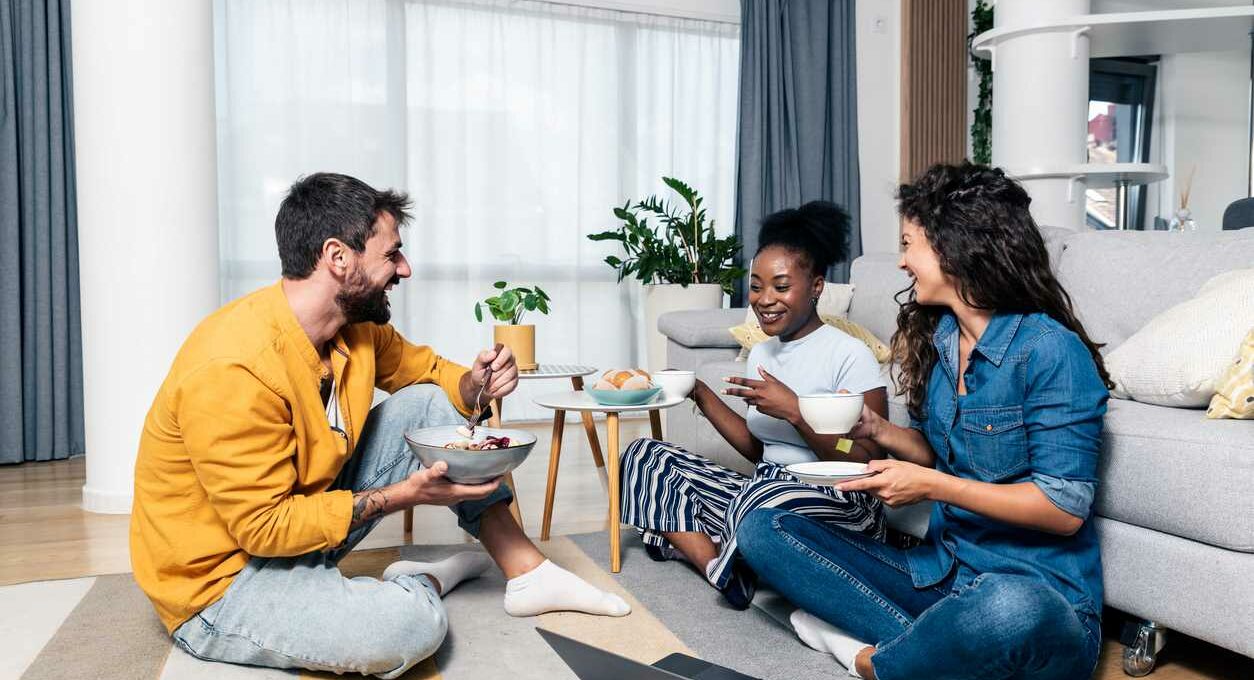 A group of friends sitting around their living room studying