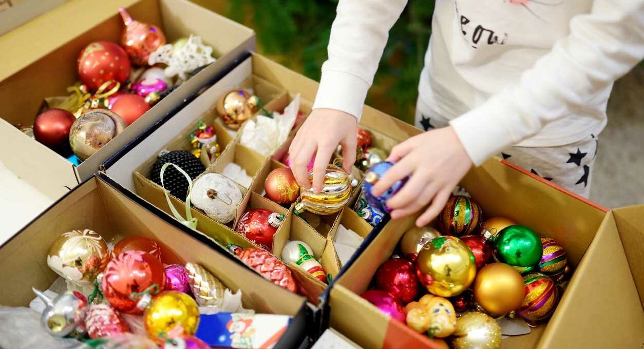 Colorful ornaments, garland, lights, and other Christmas decorations stored in a cardboard box