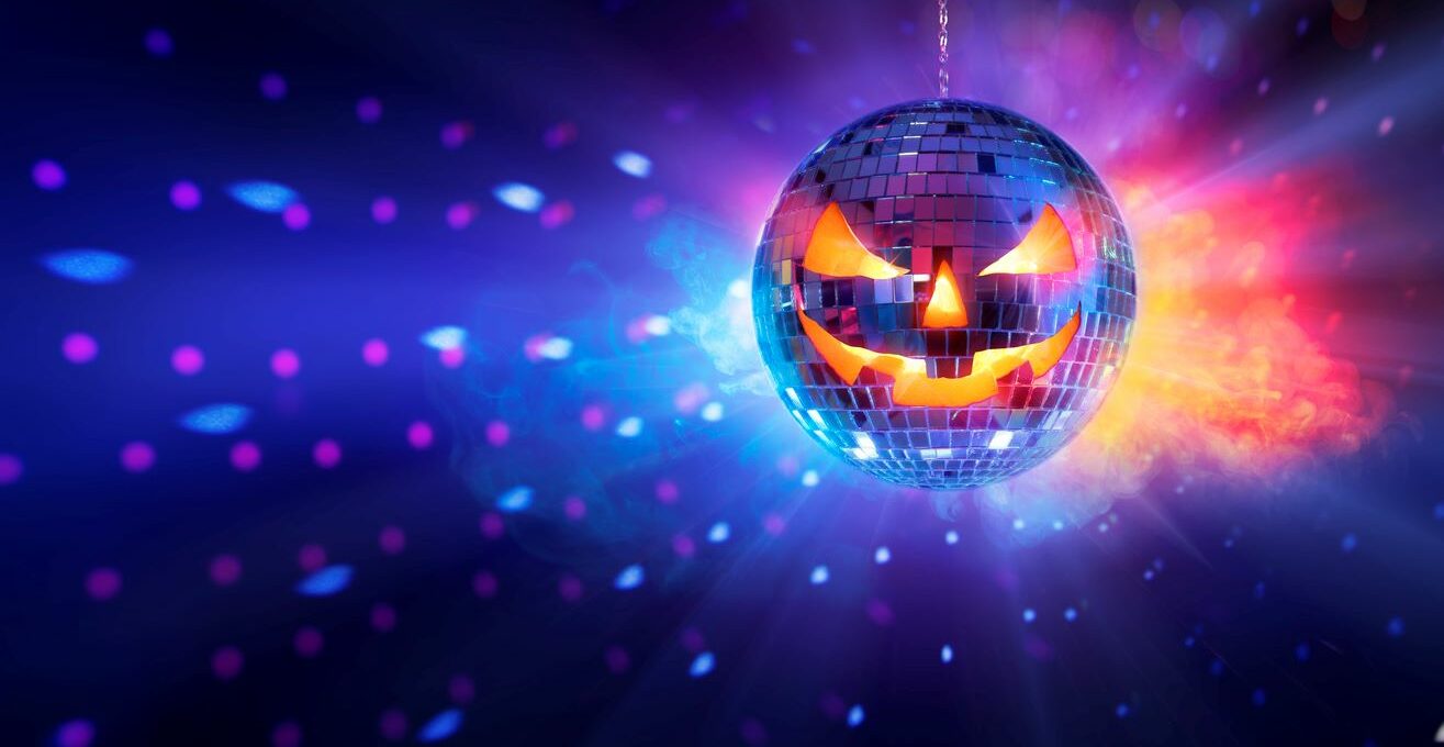 A Jack O’Lantern-style disco ball emitting blue and orange smoke and spooky disco energy