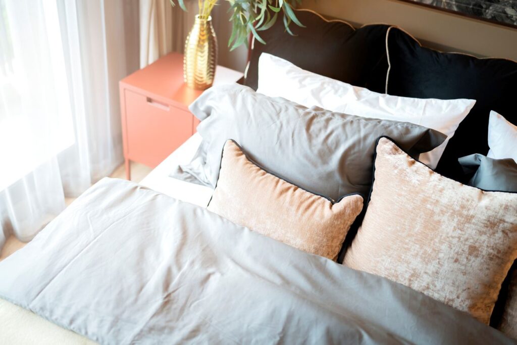 A minimalist spare bedroom with a desk, daybed, bookshelf, and large windows.