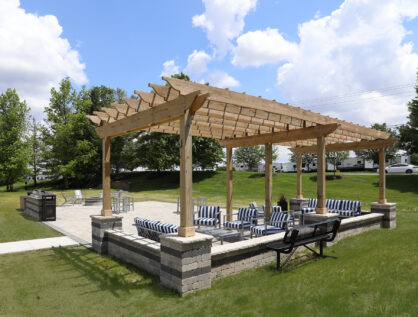 Social deck at Emerald Lakes Apartments featuring grilling stations, a fire pit, and comfortable seating areas, designed for outdoor gatherings and resident relaxation.
