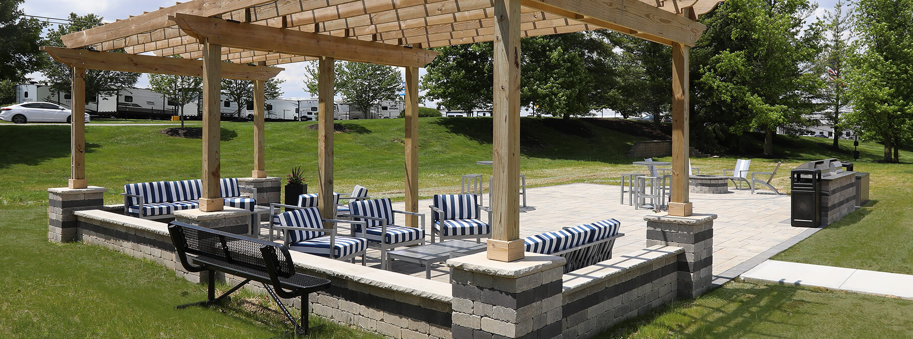 Social deck at Emerald Lakes Apartments featuring grilling stations, a fire pit, and comfortable seating areas, designed for outdoor gatherings and resident relaxation.