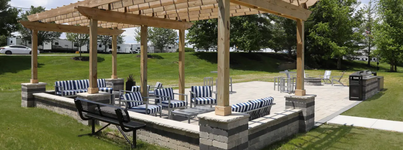 Social deck at Emerald Lakes Apartments featuring grilling stations, a fire pit, and comfortable seating areas, designed for outdoor gatherings and resident relaxation.