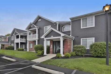 Exterior building at Wellington Place Apartments showcasing the newly updated exterior finish with modern siding, fresh paint, and well-maintained landscaping.