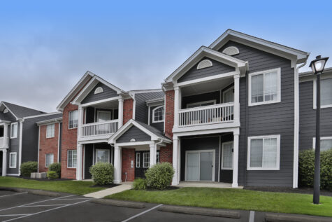Exterior building at Wellington Place Apartments showcasing the newly updated exterior finish with modern siding, fresh paint, and well-maintained landscaping.