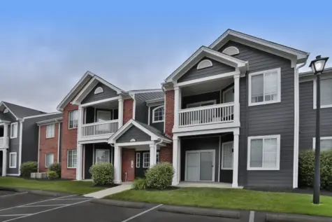 Exterior building at Wellington Place Apartments showcasing the newly updated exterior finish with modern siding, fresh paint, and well-maintained landscaping.