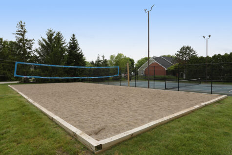Volleyball court at Wellington Place Apartments with a sand playing surface, net, and open space for residents to enjoy recreational games and outdoor fun.