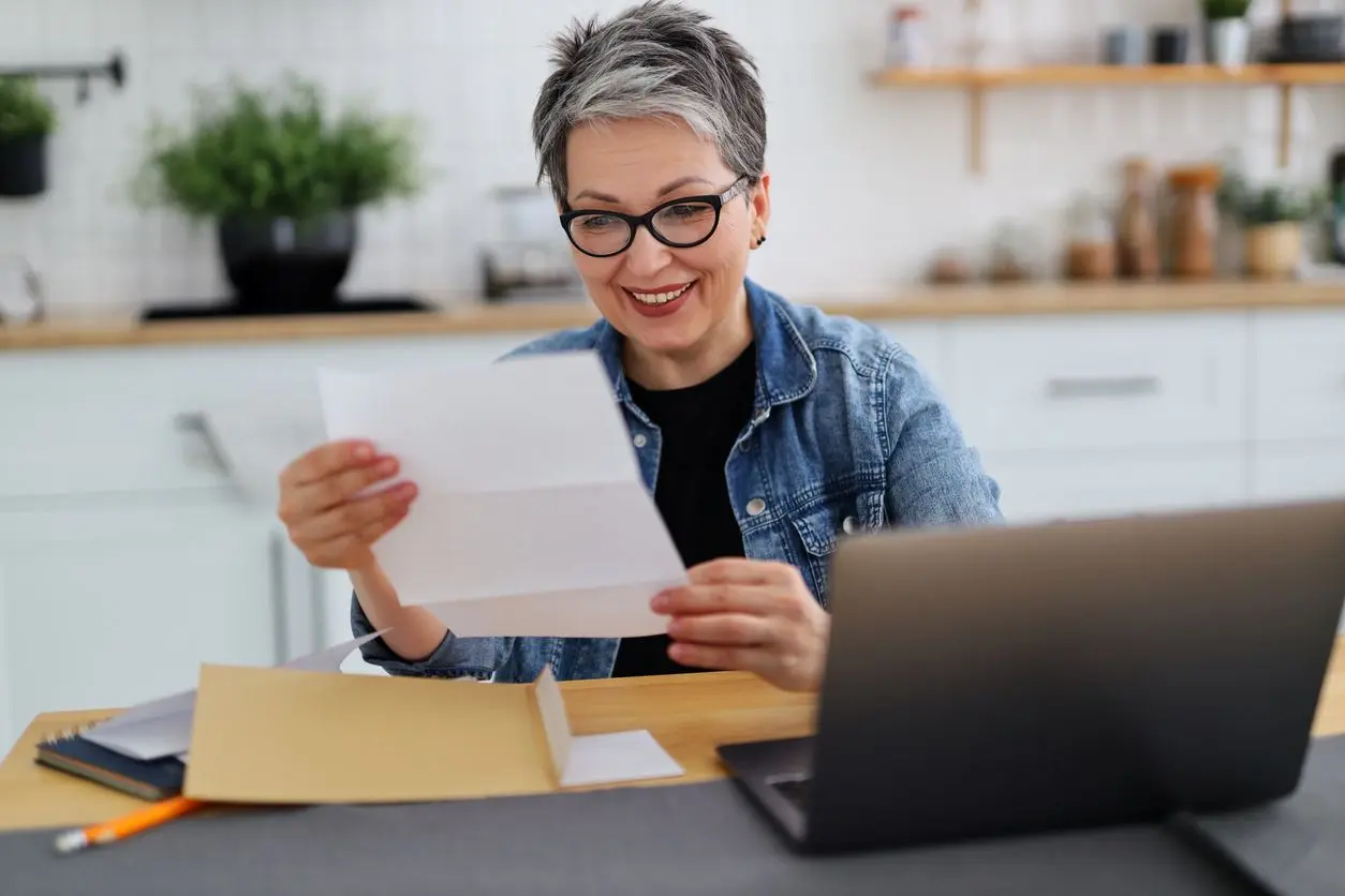 A woman reviewing her apartment lease smiling